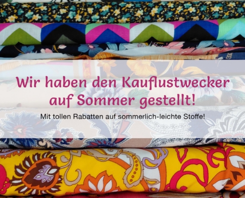 Verschiedene Sommerstoffe in Cilly's Nähkästchen – Dem Stoffgeschäft in Senden. Darauf steht: "Wir haben den Kauflustwecker auf Sommer gestellt!"
