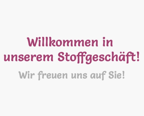 Weiße Kachel, darauf steht "Willkommen in unserem Stoffgeschäft! Wir freuen uns auf Sie!"