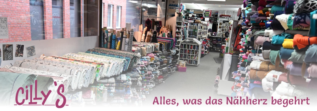 Stoffgeschäft Cilly's Zu sehen ist das Stoffgeschäft "Cilly's Nähkästchen" von innen. Man sieht jede Menge Stoffe, Garn und mehr. Darunter steht "Cilly's – Alles, was das Nähherz begehrt".